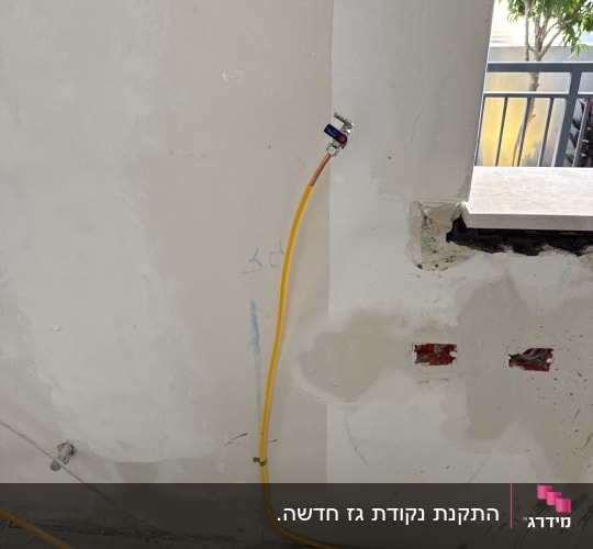 עבודת התקנת צינור גז בקיר עם כלי עבודה